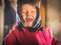 Little boy in snowsuit making funny expressions Royalty Free Stock Photo