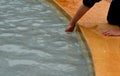 Little boy soaks his hands in the fountain. the wet edge and clear water invite you to cool off in a clear pond. spa springs heali Royalty Free Stock Photo