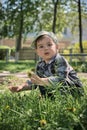 The little boy squats and collects flowers. Royalty Free Stock Photo