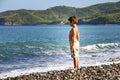 Little boy standing alone and looking at the beautiful sea. Evia island ,Greece.