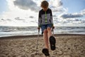 A little boy standing with crutches on the beach. Royalty Free Stock Photo