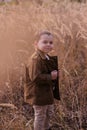 Little boy standing in a field.