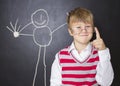 Little boy standing near the blackboard for drawing. Royalty Free Stock Photo