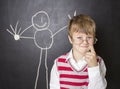 Little boy standing near the blackboard for drawing. Royalty Free Stock Photo