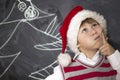 Little boy standing near the boards. Boy in Christmas hat . Royalty Free Stock Photo