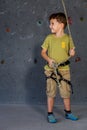 Little boy standing near a climbing rock wall indoor. Royalty Free Stock Photo