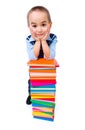 Little boy standing near stacked colorful books