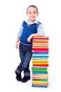 Little boy standing near stacked colorful books Royalty Free Stock Photo