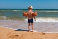 Boy standing on sea coast at surf and looking to water Royalty Free Stock Photo