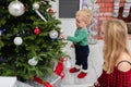 A little boy stands by the Christmas tree and looks at the Christmas decorations Royalty Free Stock Photo