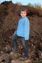 Little boy stands on earthen embankment Royalty Free Stock Photo