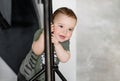 The little boy stands relying on the rack Royalty Free Stock Photo