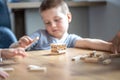 Little boy stands a turret with wooden cubes close up