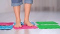 Little boy steps on orthopedic massage mats with different stiffness and texture. Feet Massage Using Trigger Point Spiky