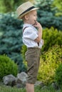 A little boy in a straw hat walks in the Park.Small ,shy boy