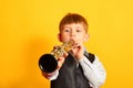 A little boy in a suit plays the clarinet