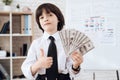 A little boy in a suit presents himself as a businessman. The dark-haired boy plays a rich man. Royalty Free Stock Photo