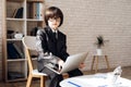 A little boy in glasses and suit presents himself as a businessman. The dark-haired boy plays a rich man. Royalty Free Stock Photo