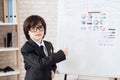 A little boy in glasses and suit presents himself as a businessman. The dark-haired boy plays a rich man. Royalty Free Stock Photo