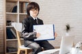 A little boy in glasses and suit presents himself as a businessman. The dark-haired boy plays a rich man. Royalty Free Stock Photo