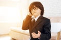 A little boy in glasses and suit presents himself as a businessman. The dark-haired boy plays a rich man. Royalty Free Stock Photo