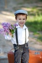 Little boy with suitcase and lilac