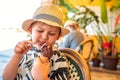 Little boy in summer hat eating chocolate ice-cream in waffle cone. Royalty Free Stock Photo