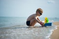 Little boy in sunglasses playing with toy boat Royalty Free Stock Photo