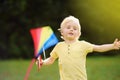 Little boy on a sunny day launches a flying kite. Royalty Free Stock Photo