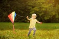 Little boy on a sunny day launches a flying kite. Royalty Free Stock Photo