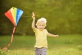 Little boy on a sunny day launches a flying kite. Royalty Free Stock Photo