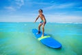 Little boy surfing sea waves standing on surfboard