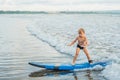 Little boy surfing on tropical beach. Child on surf board on ocean wave. Active water sports for kids. Kid swimming with Royalty Free Stock Photo