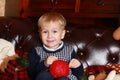 A little boy in a sweater sitting on a brown sofa Royalty Free Stock Photo