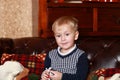 A little boy in a sweater sitting on a brown sofa Royalty Free Stock Photo