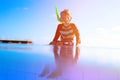 Little boy swimming diving into the pool at tropical beach