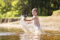 A little boy is swimming in the lake in the summer. Splashes and drops from the bathing of a young child Royalty Free Stock Photo