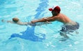 Little boy swimming with swim instructor