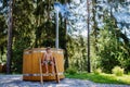 Little boy in swimsuit sitting and resting in the outdoor wooden hot tub stairs,surrounded by forest, during sunny Royalty Free Stock Photo