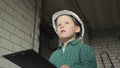 A little boy with a tablet with documents is standing on a construction site Royalty Free Stock Photo