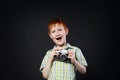 Little boy take photo with vintage camera at black background Royalty Free Stock Photo