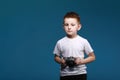 Little boy taking a picture using a retro camera. Child boy with vintage photo camera isolated on blue background. Old Royalty Free Stock Photo