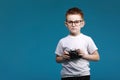 Little boy taking a picture using a retro camera. Child boy with vintage photo camera isolated on blue background. Old Royalty Free Stock Photo