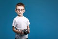 Little boy taking a picture using a retro camera. Child boy with vintage photo camera isolated on blue background. Old Royalty Free Stock Photo