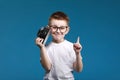 Little boy taking a picture using a retro camera and with finger pointed up. Child boy with vintage photo camera Royalty Free Stock Photo