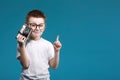 Little boy taking a picture using a retro camera and with finger pointed up. Child boy with vintage photo camera Royalty Free Stock Photo