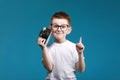 Little boy taking a picture using a retro camera and with finger pointed up. Child boy with vintage photo camera Royalty Free Stock Photo