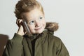 Little boy talking on the cellphone. modern child in winter coat. fashion kids.children Royalty Free Stock Photo