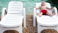 Little boy tans on the sea coastline in white deck chair