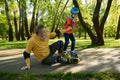 Little boy teaching old grandfather roller skating in park Royalty Free Stock Photo